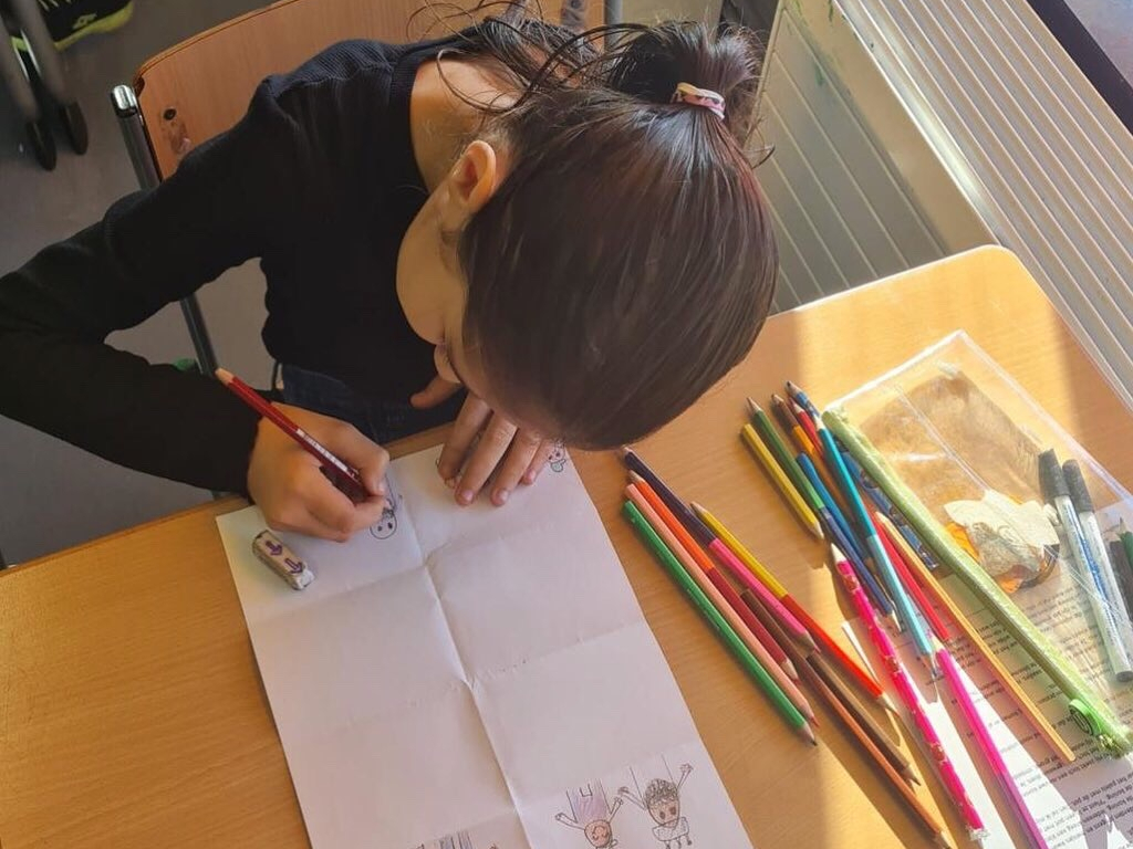 Een leerling tekent een storyboard van het verhaal dat ze gaat vertellen.